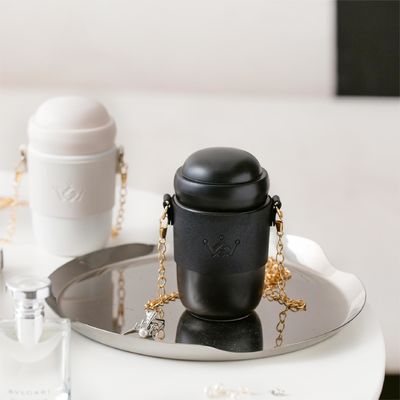 Stylish ceramic water bottle ceramic body gold-toned chain strap trendy design versatile style perfect for everyday